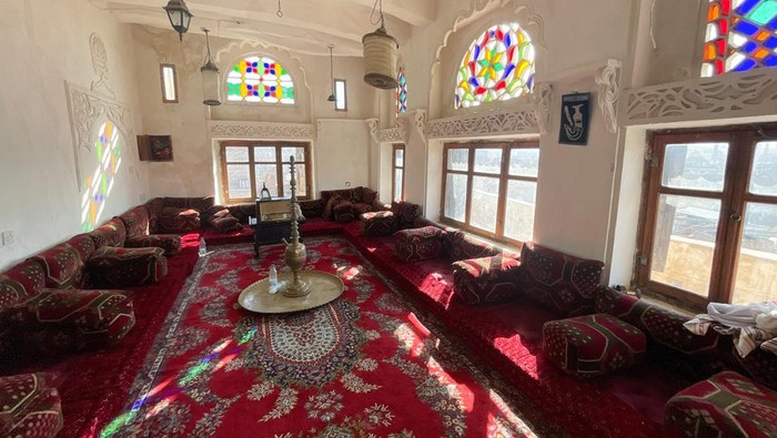 A man walks in a room adorned with Qamarias, a traditional arched plasterwork window, in Sanaa, Yemen, December 13, 2025. Such traditional window designs become increasingly rare, often replaced by modern construction techniques. REUTERS/Khaled Abdullah   REFILE - CORRECTING DATE FROM 
