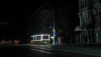 Di tengah kondisi gelap, trem-trem kota terlihat terparkir di depo karena tidak dapat beroperasi akibat terhentinya pasokan listrik. Pada malam hari, kendaraan masih tampak melintas di jalan dengan penerangan terbatas, sementara sebagian wilayah kota tenggelam dalam kegelapan. REUTERS/Nina Liashonok