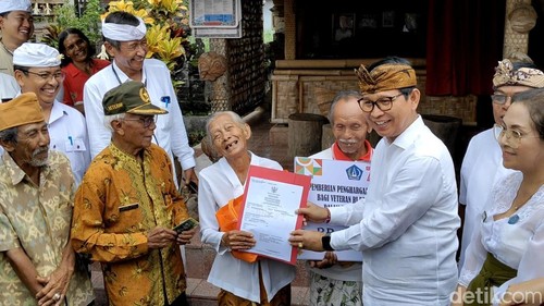 Bupati Badung I Wayan Adi Arnawa menyerahkan akta perkawinan kepada Ni Made Gangsir, istri veteran Made Kupig di Desa Baha, Mengwi, Jumat (19/12/2025). (Foto: Agus Eka/detikBali)