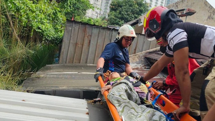 Damkar Surabaya mengevakuasi nenek yang terjebak di atap rumah
