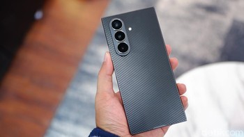 Salah satu keunggulan terbesar Galaxy Z TriFold terletak pada material punggungnya yang terbuat dari ceramic-glass fiber-reinforced polymer (CFRP). Ini bukan sekadar plastik biasa, melainkan campuran serat polimer yang diperkuat dengan serat kaca dan keramik, dirancang khusus untuk menahan benturan dan retak tanpa menambah bobot. Desain punggung ini juga punya tekstur mirip serat karbon, yang tidak hanya estetis tapi juga anti-selip.  Foto: Adi Fida Rahman/detikINET