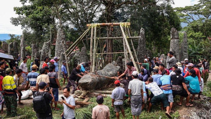 Sejumlah warga menarik menhir (simbuang batu) saat prosesi tarik batu (mangriu' batu) di Lembang Buntu Lobo, Kabupaten Toraja Utara, Sulawesi Selatan, Sabtu (20/12/2025). Prosesi tersebut merupakan rangkaian upacara pemakaman masyarakat adat Toraja (Rambu Solo) dengan menancapkan menhir di tempat upacara (Rante) sebagai simbol keabadian, status sosial dan kekuatan komunal warga setempat. ANTARA FOTO/Arnas Padda/sgd