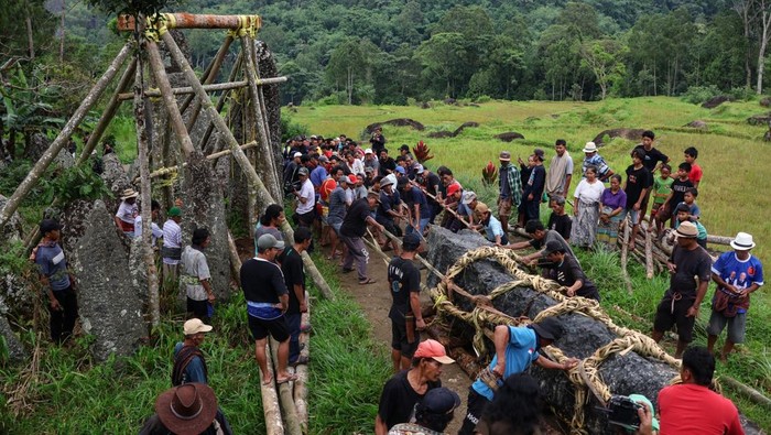 Sejumlah warga menarik menhir (simbuang batu) saat prosesi tarik batu (mangriu' batu) di Lembang Buntu Lobo, Kabupaten Toraja Utara, Sulawesi Selatan, Sabtu (20/12/2025). Prosesi tersebut merupakan rangkaian upacara pemakaman masyarakat adat Toraja (Rambu Solo) dengan menancapkan menhir di tempat upacara (Rante) sebagai simbol keabadian, status sosial dan kekuatan komunal warga setempat. ANTARA FOTO/Arnas Padda/sgd