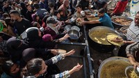 Warga Palestina yang mengungsi tampak mengantre untuk menerima jatah makanan di dapur amal di Kamp Pengungsi Nuseirat, Jalur Gaza bagian tengah, kemarin. AFP/EYAD BABA