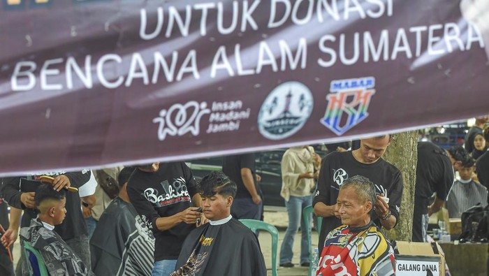 Kapster dari Seni Rambut Provinsi Jambi memangkas rambut warga saat penggalangan dana melalui aksi pangkas rambut bayar seikhlasnya di Taman Banjuran Budayo, Kota Baru, Jambi, Minggu (21/12/2025). Aksi yang diikuti 70 kapster se-Provinsi Jambi itu bertujuan menggalang dana untuk didonasikan ke warga korban bencana alam di Aceh, Sumatera Utara, dan Sumatera Barat. ANTARA FOTO/Wahdi Septiawan/bar