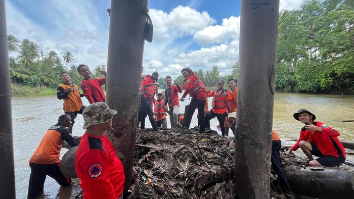 BPBD OKU Bersihkan Sampah Pohon Menumpuk di Tiang Jembatan