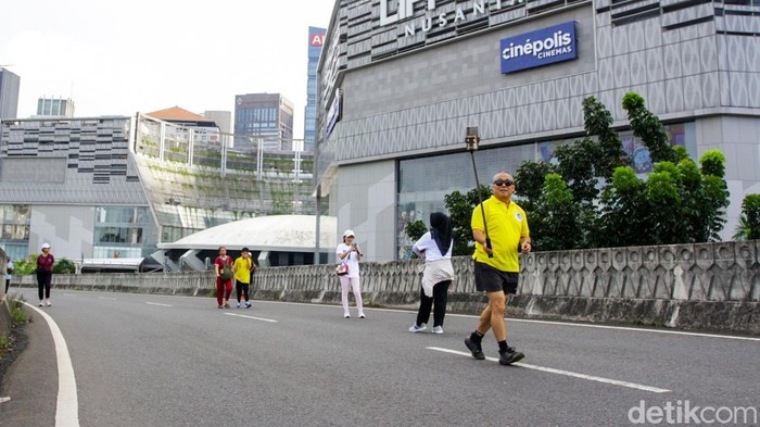 Warga berjalan kaki menikmati suasana Hari Bebas Kendaraan Bermotor (HBKB) di kawasan Sudirman, Jakarta, Minggu (21/12/2025).