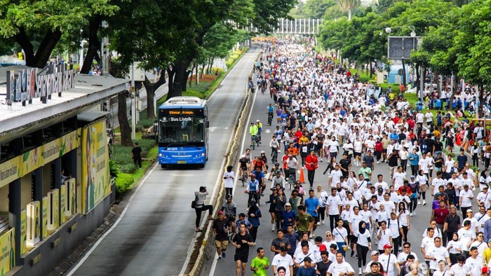 Warga berjalan kaki menikmati suasana Hari Bebas Kendaraan Bermotor (HBKB) di kawasan Sudirman, Jakarta, Minggu (21/12/2025).