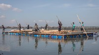 Fondasi bantuan program rumah apung diangkut melalui jalur perairan akibat genangan banjir rob yang telah menjadi kondisi permanen di kawasan pesisir. Foto: ANTARA FOTO/Aji Styawan