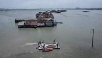 Warga menarik fondasi rumah apung menggunakan perahu motor menuju lokasi pembangunan di Desa Timbulsloko, Demak, Jawa Tengah. Foto: ANTARA FOTO/Aji Styawan