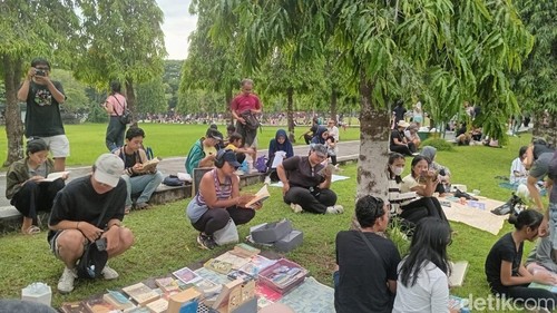 Sejumlah pengunjung lapak Rindu Dibaca membaca buku gratis di Lapangan Monumen Bajra Sandhi, Renon, Denpasar, Bali, Minggu (21/12/2025). (Foto: Hani Sofia Muthmainnah/detikBali)