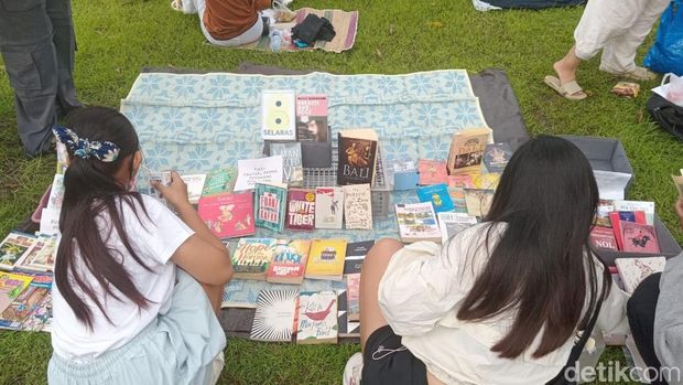 Sejumlah pengunjung lapak Rindu Dibaca membaca buku gratis di Lapangan Monumen Bajra Sandhi, Renon, Denpasar, Bali, Minggu (21/12/2025). (Foto: Hani Sofia Muthmainnah/detikBali)