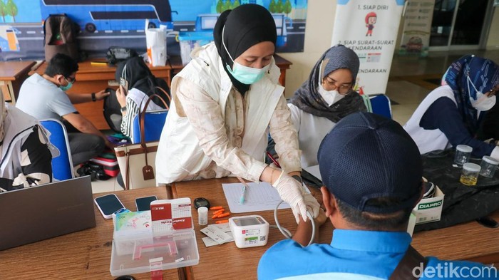 Petugas kesehatan melayani pemeriksaan sopir bus di pos kesehatan Terminal Pulo Gebang, Jakarta Timur, Minggu (21/12/2025), jelang lonjakan arus Nataru.