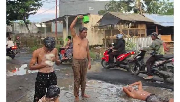 Viral video Kades Bonder di Kecamatan Praya Barat, Lombok Tengah, mandi lumpur di ruas jalan Desa Penujak-Selong Belanak. (Foto: Facebook @Dneq_Husen)