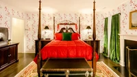 Renovasi juga turut mengubah ruang kamar. Meskipun masih dengan nuansa lama, yaitu ranjang yang khas dengan 4 tiang kayu beserta sprei merah, ruangan ini juga dipoles dengan lebih modern. Walaupun masih bermotif, wallpaper dinding juga diubah menjadi lebih modern. Tirai putih berenda yang khas di versi sebelumnya juga sudah tidak dipasang, digantikan tirai yang nuansanya lebih modern. Foto: New York Post