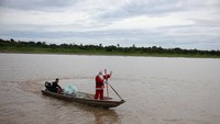 Jorge Alberto Barrozo, anggota kelompok Sahabat Sinterklas, tiba dengan mengenaka kostum sinterklas untuk mengantarkan mainan ke komunitas tepi sungai, di sepanjang Sungai Amazon, di Careiro da Varzea, negara bagian Amazonas, Brasil. REUTERS/Bruno Kelly