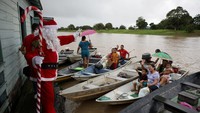 Sinterklas membagikan hadiah kepada anak-anak sebagai bagian dari inisiatif sosial yang bertujuan membawa kegembiraan Natal ke komunitas sungai Amazon. REUTERS/Bruno Kelly