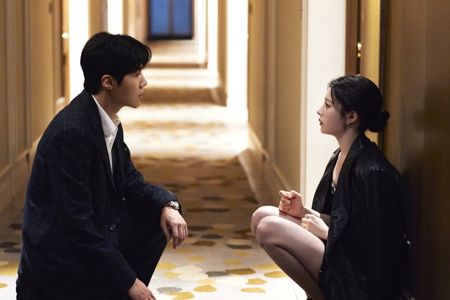 Suasana menegangkan terasa saat mereka duduk di sebuah lorong hotel dalam balutan busana formal. Terdapat masalah tak terduga yang harus dihadapi saat Kim Seon Ho menjadi interpreter untuk Go Yoon Jung di luar negeri. Foto: dok. Netflix
