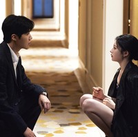 Suasana menegangkan terasa saat mereka duduk di sebuah lorong hotel dalam balutan busana formal. Terdapat masalah tak terduga yang harus dihadapi saat Kim Seon Ho menjadi interpreter untuk Go Yoon Jung di luar negeri. Foto: dok. Netflix