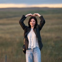 Bikin gemas. Go Yoon Jung tampak memberikan heart sign kepada Kim Seon Ho di belakang pemandangan hijau. Berbeda dengan Joo Ho Jin yang tampak tenang dan terkendali, Cha Mu Hee memiliki pesona yang tak terduga. Foto: dok. Netflix