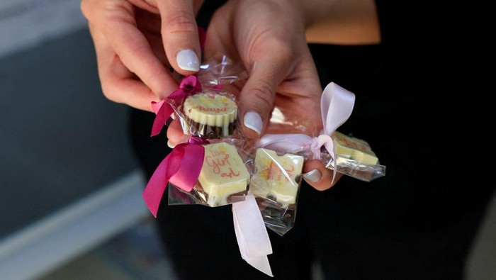 Palestinian Maria Khoury gives samples of her chocolates in a Christmas market, in the Manger Square, near the Church of the Nativity in Bethlehem in the Israeli-occupied West Bank, December 14, 2025. REUTERS/Mussa Qawasma