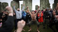Kerumunan merayakan momen matahari terbit yang sejajar dengan sumbu utama Stonehenge, memperkuat keyakinan bahwa situs ini dirancang dengan penyelarasan astronomi, khususnya pada winter solstice. REUTERS/Isabel Infantes