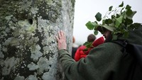 Seorang pengunjung menyentuh batu Stonehenge, bagian dari ritual refleksi dan penghormatan terhadap monumen prasejarah berusia sekitar 5.000 tahun. REUTERS/Isabel Infantes