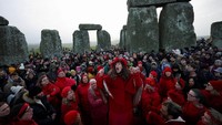 Ribuan orang berkumpul di dalam dan sekitar lingkaran batu Stonehenge sebelum fajar untuk menyambut matahari terbit pada winter solstice, hari terpendek dalam setahun di belahan bumi utara. REUTERS/Isabel Infantes