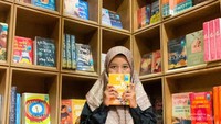 Foto penulis di depan rak Bookcess