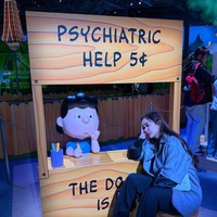 Pose di depan instalasi bertema kartun The Peanuts, wanita 38 tahun ini memilih gaya layering dengan memadukan jaket dan celana hitam serta cardigan lengan pendek. Foto: Instagram/@aurakasih