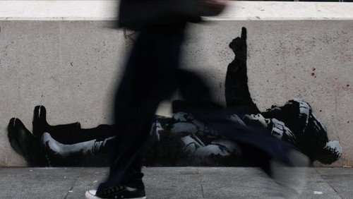 Sebuah mural baru yang diduga merupakan karya seniman anonim Banksy mencuri perhatian publik di Tottenham Court Road, London, Inggris, Selasa (22/12/2025). Mural tersebut langsung menyedot perhatian pejalan kaki dan pengguna jalan yang melintas di kawasan pusat kota London itu. REUTERS/Isabel Infantes