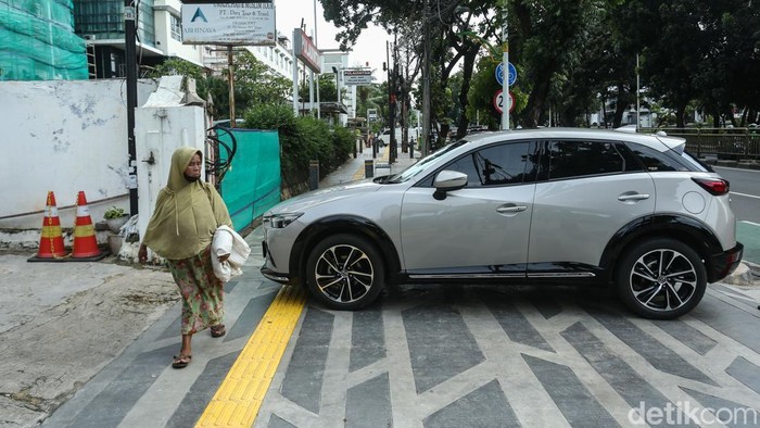Pejalan kaki melintas di trotoar kawasan Tebet, Jakarta, Selasa (23/12/2025), yang baru selesai direvitalisasi oleh Pemprov DKI Jakarta.