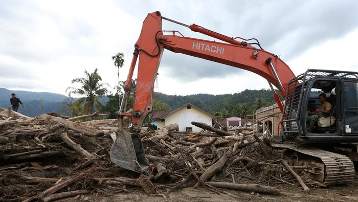 Petugas mengoperasikan alat berat untuk membersihkan lumpur dan kayu gelondongan yang menutupi badan jalan lintas penghubung Kabupaten Aceh Timur dengan Kabuopaten Gayo Lues di Lokop, Serbajadi, Aceh Timur, Aceh, Senin (22/12/2025). Pemerintah mengerahkan belasan alat berat untuk membebaskan keterisolasian daerah pedalaman Aceh Timur pascabencana hidrometeorologi Aceh pada akhir November 2025. ANTARA FOTO/Irwansyah Putra
