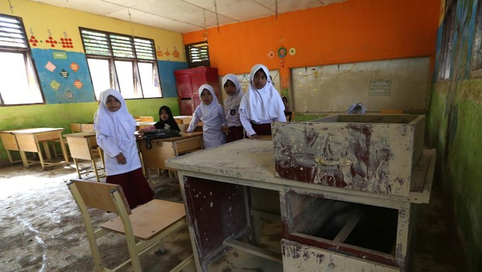 Pelajar menjemur Alquran dan buku pelajran yang tergenang banjir bandang di SD Negeri Seuneubok Johan, Ranto Peureulak, Aceh Timur, Aceh, Selasa (23/12/2025). Data sementara posko tanggap darurat bencana hidrometeorologi Aceh menyebutkan sebanyak 452 unit sekolah yang tersebar di 18 Kabupaten dan kota di Provinsi Aceh tergenang lumpur dan rusak akibat bencana banjir bandang akhir November 2025 yang sebagian kecilnya sudah memulai aktivitas belajar mengajar. ANTARA FOTO/Irwansyah Putra