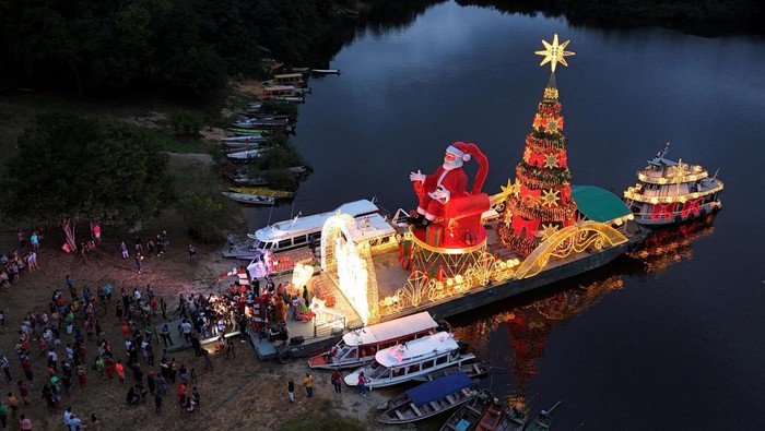 A drone view shows a giant Santa Claus aboard a Christmas ferry, delivering holiday baskets and toys to the riverside community of Bela Vista do Jaraqui during the 'Natal das Aguas' event organized by the Manaus city hall at the banks of Rio Negro in Manaus, Amazonas state, Brazil, December 18, 2025. REUTERS/Bruno Kelly     TPX IMAGES OF THE DAY