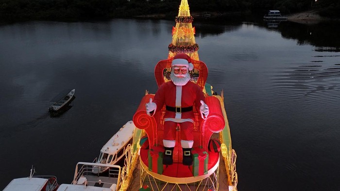 A drone view shows a giant Santa Claus aboard a Christmas ferry, delivering holiday baskets and toys to the riverside community of Bela Vista do Jaraqui during the 'Natal das Aguas' event organized by the Manaus city hall at the banks of Rio Negro in Manaus, Amazonas state, Brazil, December 18, 2025. REUTERS/Bruno Kelly     TPX IMAGES OF THE DAY