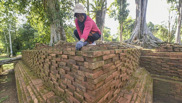 Juru pelihara membersihkan struktur situs Candi Parit Duku yang telah selesai dipugar di Kawasan Cagar Budaya Nasional (KCBN) Muarajambi, Muaro Jambi, Jambi, Selasa (23/12/2025). Kementerian Kebudayaan mendorong percepatan pemugaran situs-situs di kawasan yang diyakini sebagai peninggalan penting masa Kerajaan Sriwijaya dalam rangka pengembangan ilmu pengetahuan serta peningkatan ekonomi masyarakat sekitar. ANTARA FOTO/Wahdi Septiawan.