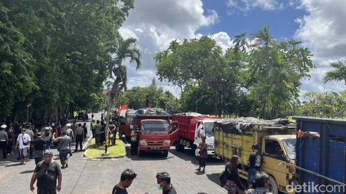 Ratusan sopir truk sampah memarkir kendaraannya di depan Kantor Gubernur Bali sebagai aksi penolakan penutupan TPA Suwung, Selasa (23/12/2025). (Foto: Rizki Setyo/detikBali)