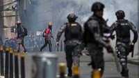 Polisi antihuru-hara berjaga saat massa menolak alasan pemerintah yang menyebut penghapusan subsidi BBM diperlukan untuk menghemat hingga US$10 juta per hari dan menstabilkan ekonomi di tengah krisis devisa dan inflasi. REUTERS/Claudia Morales
