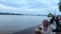 Sambil jajan, pengunjung bisa duduk santai memandangi Sungai Segah dan senja.