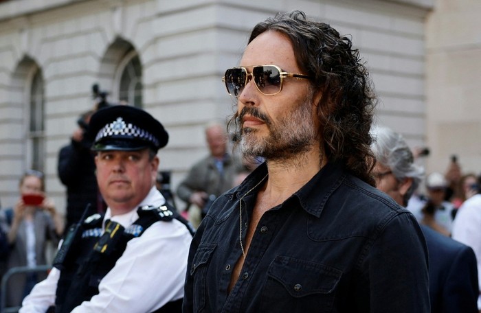 (FILES) British actor and comedian Russell Brand departs Westminster Magistrates Court in London on May 2, 2025. UK police said two new charges, of rape and sexual assault, had been issued on December 23, 2025 against British comedian and actor Russell Brand. (Photo by BENJAMIN CREMEL / AFP)