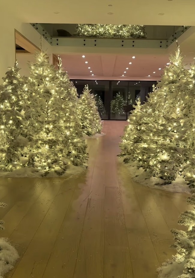 Dekorasi tersebut ia pamerkan lewat video Instagram Stories pada awal Desember. Dalam video itu, Kim tampak berjalan menyusuri rumahnya yang berubah menjadi ‘hutan musim dingin’,  lengkap dengan pohon-pohon cemara tinggi yang diselimuti salju buatan dan lampu putih berkilauan. Foto: dok. Instagram @kimkardashian