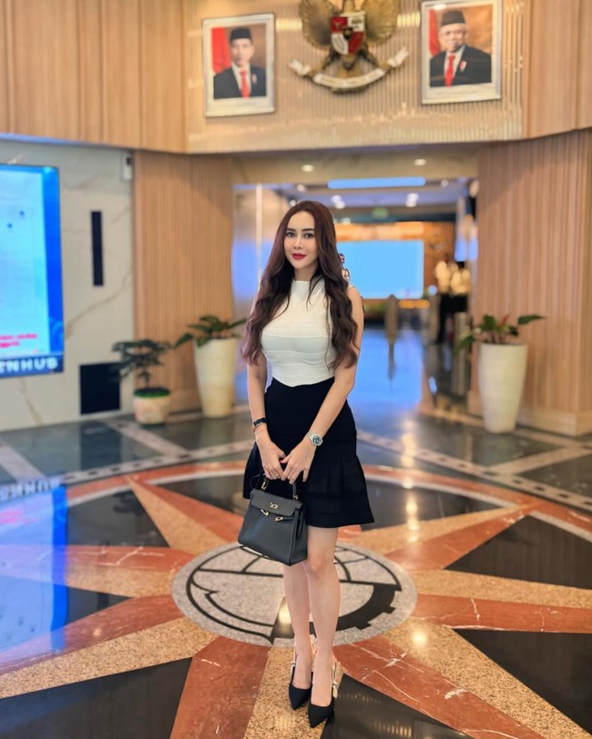 Tampil dengan gaya klasik perpaduan hitam-putih, bintang film ‘Rumah Iblis’ ini tampak membawa tas Hermes Kelly hitam. Foto: Instagram/@aurakasih