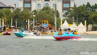 Sejumlah keluarga memilih naik perahu wisata untuk menikmati suasana laut, salah satu aktivitas favorit pengunjung di Pantai Ancol.