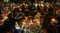 Warga keturunan Portugis menyalakan lilin dan menaruh bunga saat ziarah ke makam anggota keluarga saat malam Natal di kompleks Gereja Protestan Indonesia Barat (GPIB) Tugu, Semper Barat, Cilincing, Jakarta, Rabu (24/12/2025). Ziarah makam tersebut sudah menjadi tradisi keluarga keturunan Portugis di Kampung Tugu sebagai bentuk penghormatan dan mendoakan anggota keluarga yang telah wafat. Foto: ANTARA FOTO/Sulthony Hasanuddin