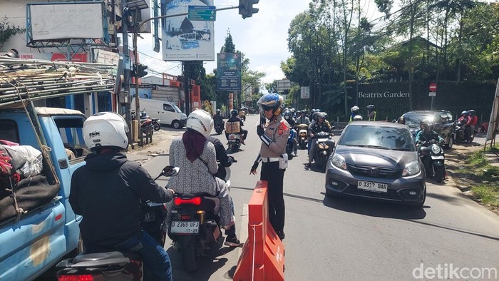 Polisi melakukan pengaturan lalu lintas di jalan raya Lembang