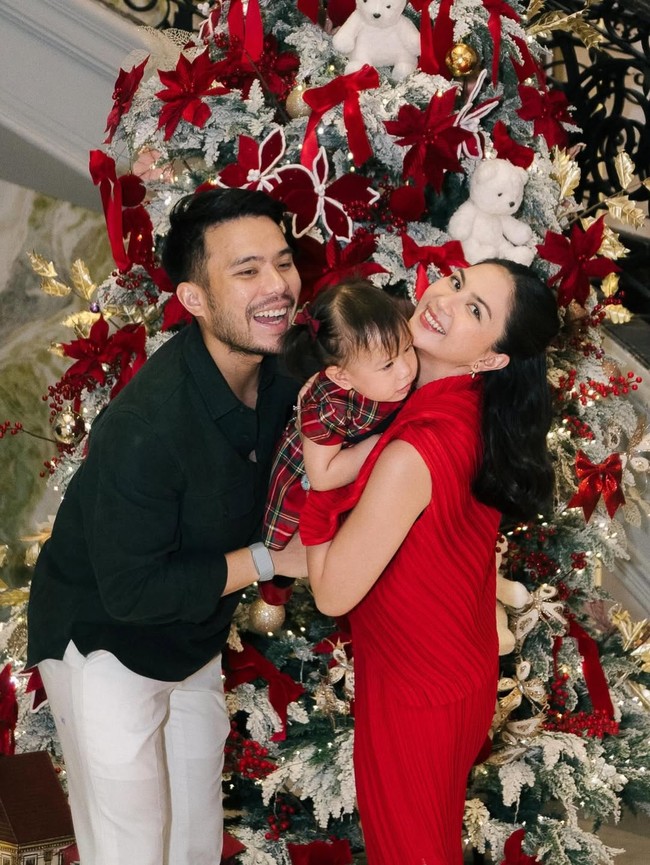 Aktris Jessica Mila dan suami, pengacara Yakup Hasibuan, merayakan Natal dengan penuh suka cita. Jessica tampil chic berbalut setelan lipit merah, sementara Yakup memilih gaya simple memadukan kemeja hitam dan celana putih. Foto: Instagram/@jscmila