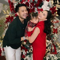 Aktris Jessica Mila dan suami, pengacara Yakup Hasibuan, merayakan Natal dengan penuh suka cita. Jessica tampil chic berbalut setelan lipit merah, sementara Yakup memilih gaya simple memadukan kemeja hitam dan celana putih. Foto: Instagram/@jscmila