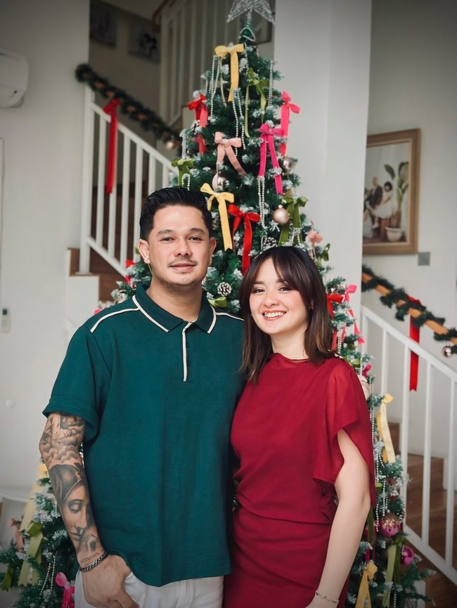 Aktris Joanna Alexandra pun merayakan Natal dengan nuansa merah. Ibu empat anak ini tampak berpose dengan kekasihnya, Immanuel Christover. Joanna tampil chic mengenakan gaun merah aksen ruffle. Foto: Instagram/@joannaalexandra