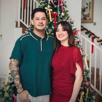 Aktris Joanna Alexandra pun merayakan Natal dengan nuansa merah. Ibu empat anak ini tampak berpose dengan kekasihnya, Immanuel Christover. Joanna tampil chic mengenakan gaun merah aksen ruffle. Foto: Instagram/@joannaalexandra